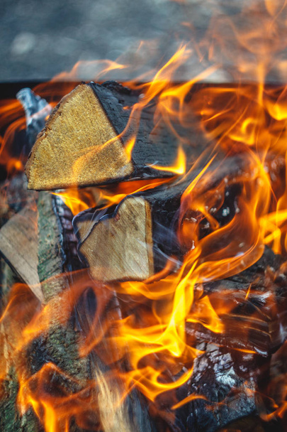 Brennendes Feuer im Grill mit Holzscheiten. Nahaufnahme. Waldkonzept - Foto, Bild