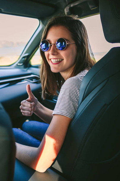 Girl doing thumbs up in the car - Photo, Image