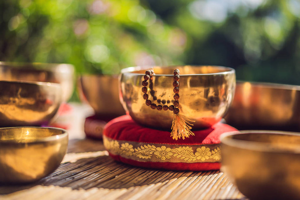 Tibetan singing bowls on a straw mat - Fotoğraf, Görsel