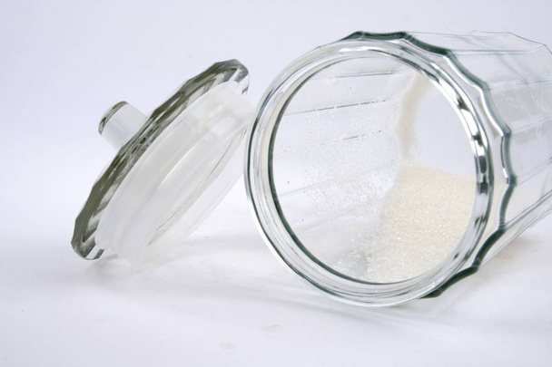 Beyaz arkaplanda cam şeffaf vazoda şeker - Fotoğraf, Görsel