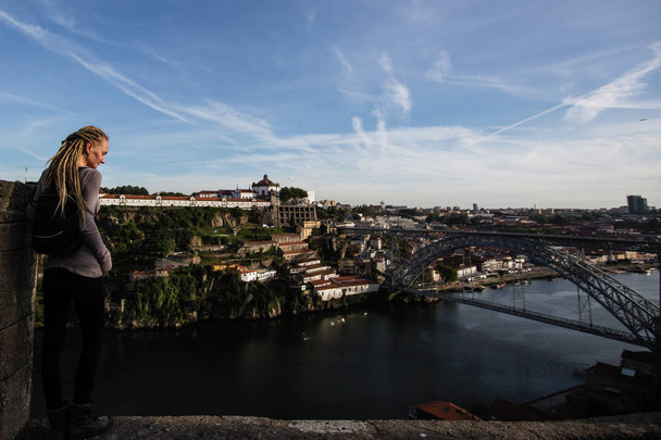 Young woman enjoying view of Douro river and Dom Luis I bridge, Porto, Portugal. - 写真・画像