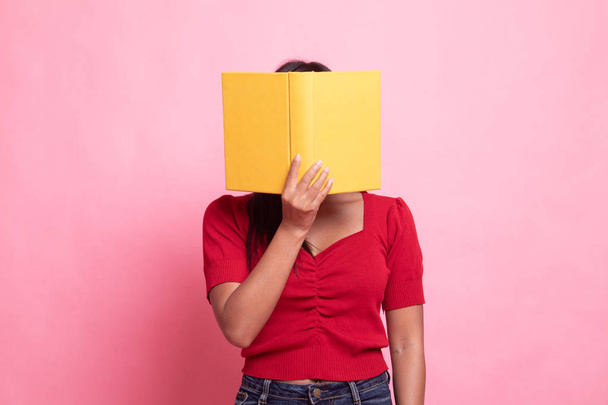 Young Asian woman with a book cover her face. - Fotoğraf, Görsel