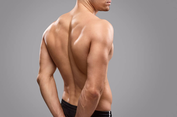 Crop athlete demonstrating back muscles - 写真・画像