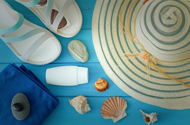 a holiday photo, a summer hat, beach sandals, sunscreen, sun glasses, scallops and souvenir pebbles.  - Foto, imagen