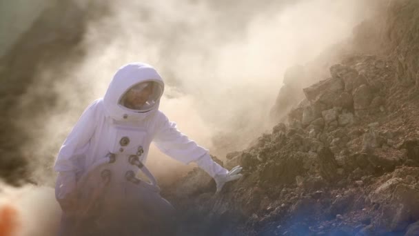 Odważny astronauta w garniturze kosmicznego eksploruje czerwoną planetę Mars pokrytą mgłą. Przygoda. Podróże kosmiczne, świat zamieszkany i koncepcja kolonizacji - Materiał filmowy, wideo