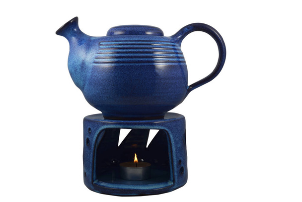 синій керамічний чайник зі свічкою, нагрітою на білому
 - Фото, зображення