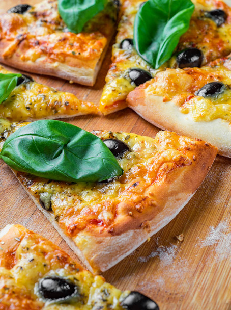 Pizza with Mozzarella cheese, Tomatoes, pepper, olive, Spices and Fresh Basil. Italian pizza. Pizza Margherita or Margarita on wooden table background - Foto, Imagem