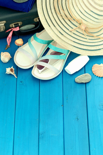 a nyaralás fotó, egy nyári kalap, strandpapucs, fényvédő, napszemüvegek, Fésűkagylók és szuvenír kavics. Üres hely a feliratnak - Fotó, kép