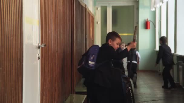 boy with hockey equipment hit by door in school hallway - Filmmaterial, Video