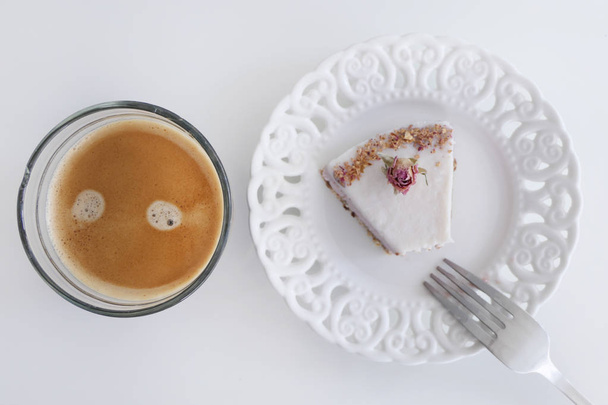 Vegan fruit cake eten met een rozen decoratie en een kopje koffie - Foto, afbeelding