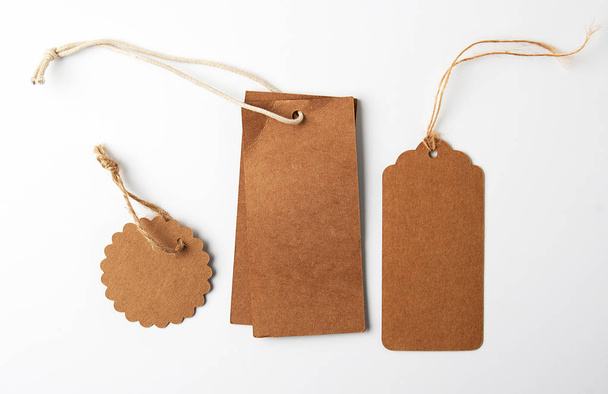 diverses étiquettes en papier brun avec cordes sur fond blanc
 - Photo, image