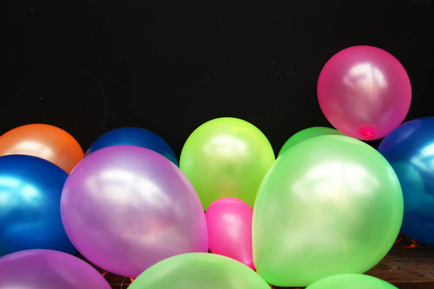close-up weergave van kleurrijke ballonnen op de zwarte achtergrond - Foto, afbeelding
