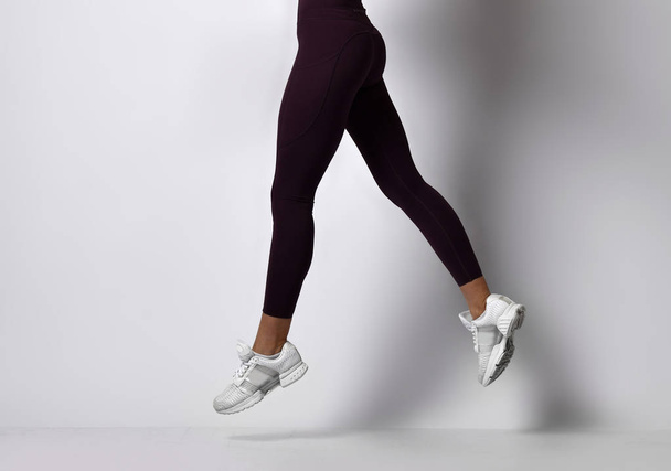 Sporty woman legs walking in sport wear on a white - Foto, Imagen