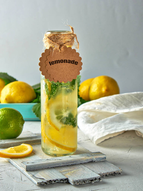  lemonade with lemons, mint leaves, lime in a glass bottle - Photo, Image