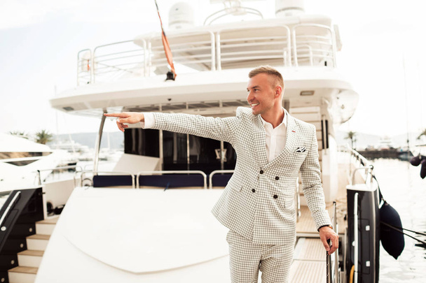 Stylish businessman is standing on his luxury yacht is wearing fashion costume. Montenegro bay - Photo, Image