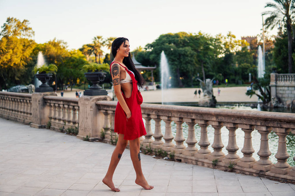 Travestieten getatoeëerd transgender model is dansen in het groene park - Foto, afbeelding