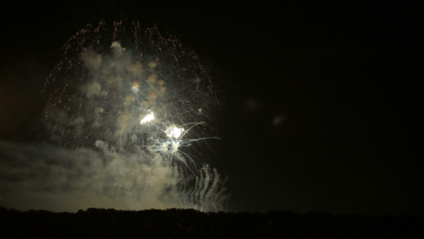 Káprázatos nagyszabású tűzijáték, világos fénnyel a horizont felett. Élő kamera - Felvétel, videó