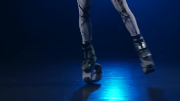 Close-up slow motion, legs in kangoo jumps shoes against blue spotlight. - Séquence, vidéo