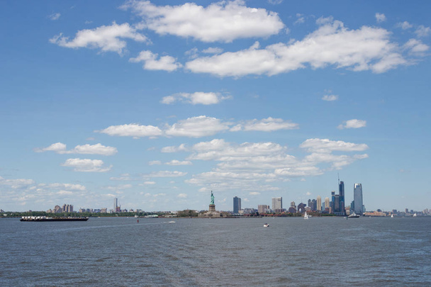On the horizon are seen the skyscrapers of New York. Skyscrapers of New York in the distance. Bay, blue sky, sunny summer day in New York. - Foto, afbeelding