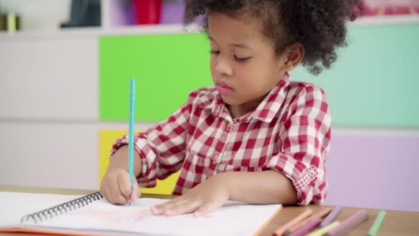 Afrikanische Kinder zeichnen und machen Hausaufgaben im Klassenzimmer, junge Mädchen freuen sich über lustiges Lernen und spielen in der Grundschule Papiermalerei. Kinderzeichnen und Malen im Schulkonzept. - Filmmaterial, Video