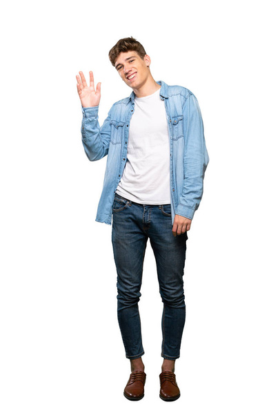 A full-length shot of a Handsome young man saluting with hand with happy expression over isolated white background - Фото, зображення