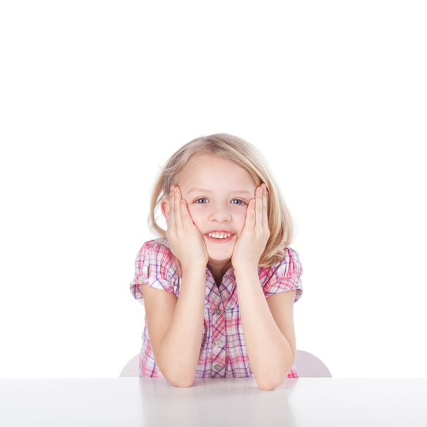 Girl With Hands On Cheeks Sitting At Table - Photo, Image