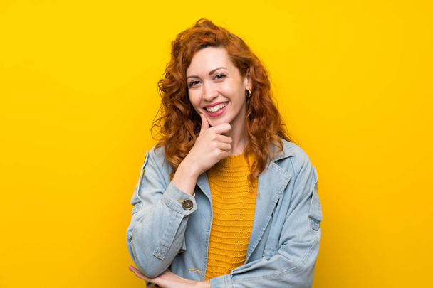 rothaarige Frau über isoliertem gelben Hintergrund lacht - Foto, Bild