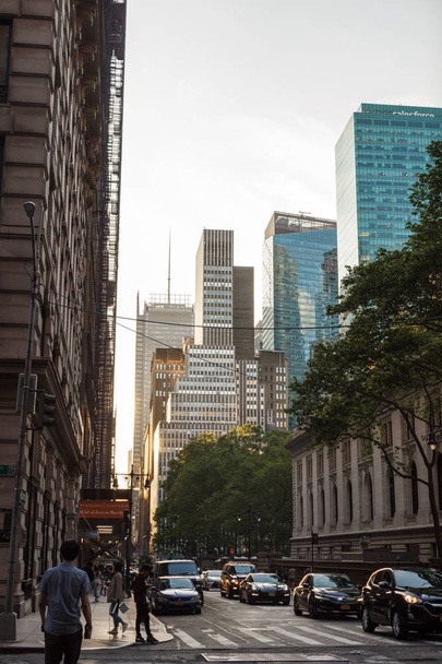 New York, NY / USA - toukokuu / 27 / 2019: New Yorkin arkkitehtuuri. Ihmiset kävelevät kadulla pilvenpiirtäjien keskellä.
. - Valokuva, kuva