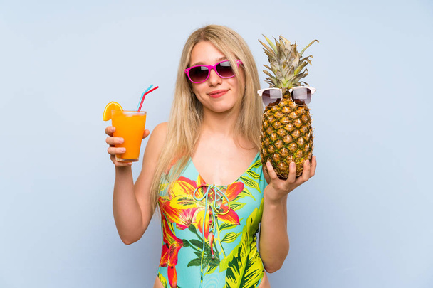 Jeune femme en maillot de bain tenant un ananas avec des lunettes de soleil
 - Photo, image