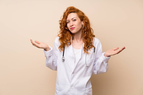 Κοκκινομάλλα γιατρός γυναίκα που έχει αμφιβολίες με σύγχυση έκφραση προσώπου - Φωτογραφία, εικόνα