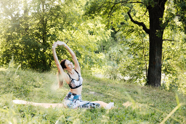 a lány részt fitness és meditál a parkban város - Fotó, kép