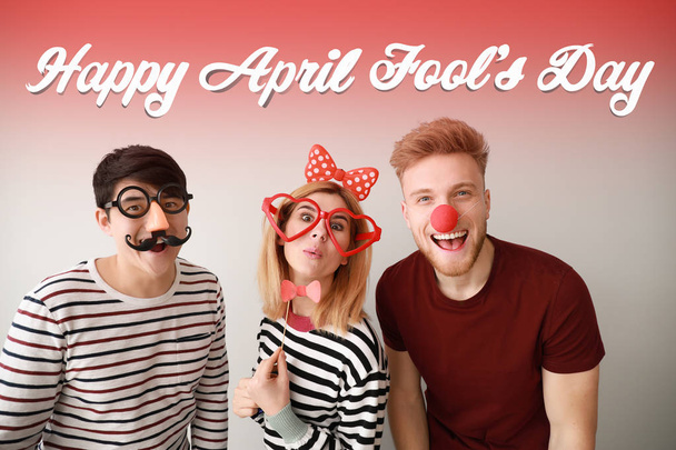 Funny friends with party decor for April Fools' Day celebration on light background - Photo, Image