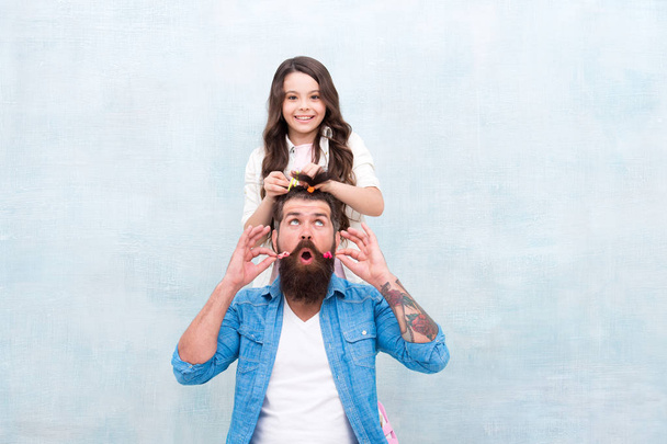 Change hairstyle. Daughter hairstylist. Enjoy fatherhood. Happy moment. Raising girl. Create funny hairstyle. Child making hairstyle styling father beard. Being parent means present for kid interests - Foto, Imagem