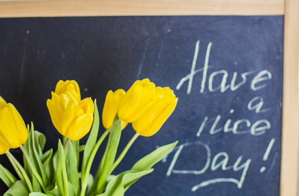 Gelbe Tulpen und Kreideschrift auf Tafel "Guten Tag"!" - Foto, Bild