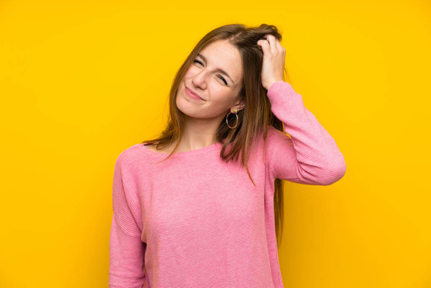 Молода жінка з довгим волоссям над ізольованою жовтою стіною з виразом розчарування і нерозуміння
 - Фото, зображення