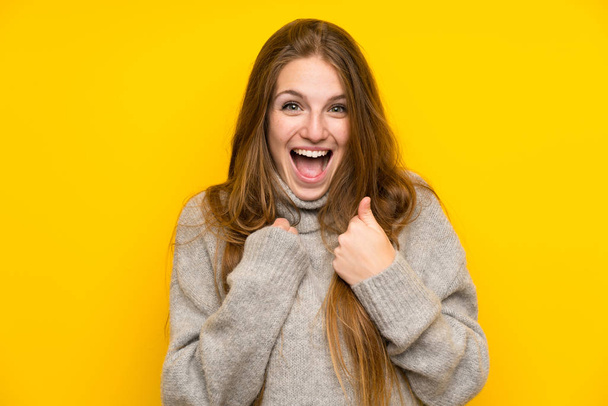 Young woman with long hair over yellow background celebrating a victory - 写真・画像