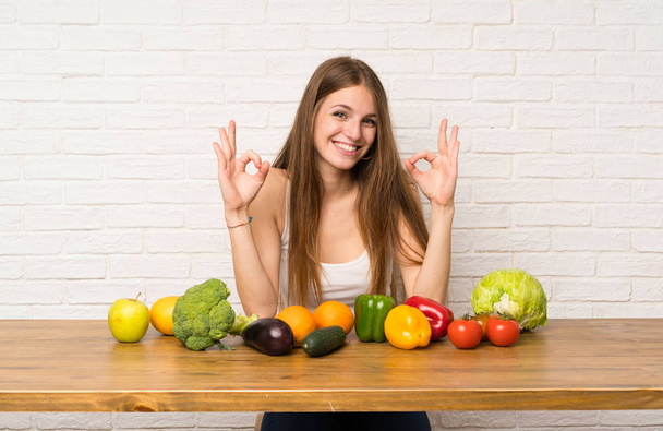 Молодая женщина с большим количеством овощей, показывающих ОК знак с пальцами
 - Фото, изображение