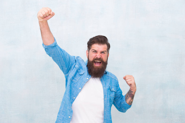 Celebration concept. Brutal handsome hipster man on grey wall background. Bearded man trendy hipster style. Cheerful mood. Happiness and joy. Hipster with beard and mustache happy expression - Zdjęcie, obraz