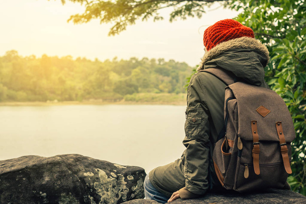 Men with backpack the sit and watch beautiful nature. - Foto, imagen