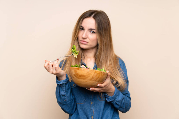 Giovane donna con insalata su sfondo isolato
 - Foto, immagini