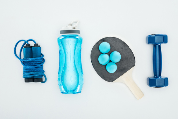 вид сверху на спортивную бутылку рядом с мячами для пинг-понга и спортивным оборудованием, изолированным на белом
  - Фото, изображение