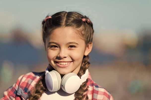 Girl child listen music outdoors with modern headphones. Music account playlist. Customize your music. Discovering new music styles is great way into culture. Kid little girl listen song headphones - Fotoğraf, Görsel