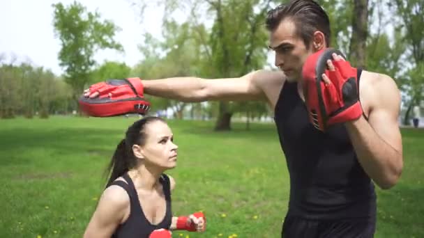 4. Boxer training of  man and woman with  boxing paws. City park outdoor . Steady  shot  - Footage, Video
