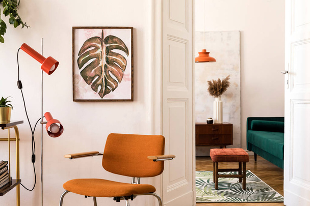 Stylish compositon of retro home interior with mock up poster frame, vintage orange chair, velvet sofa, design lamps, gold shelf, plants and elegant accessories. Nice home decor of living rooms.  - Foto, imagen