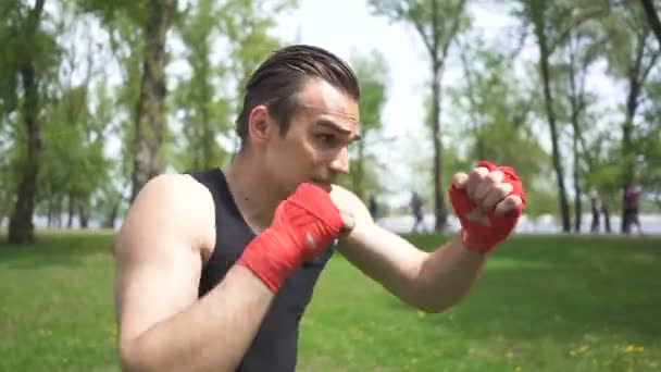 4. Muscular man boxer training with  shadow. Blows in camera, face close up. City park outdoor  boxing steady shot - Footage, Video