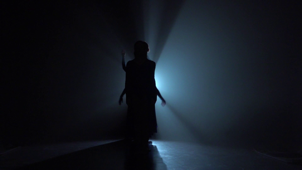Bailarinas emocionales bailando en la oscuridad sobre focos mágicos. Movimiento lento
 - Metraje, vídeo