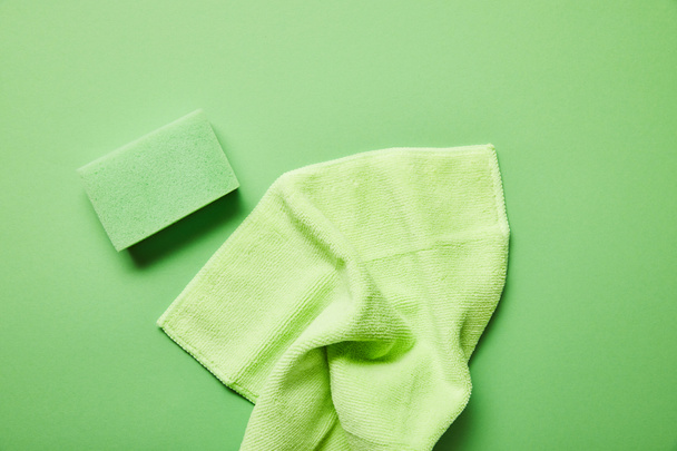 top view of colorful rag and sponge on green background  - Foto, Imagem