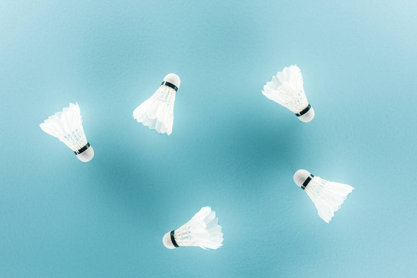 white badminton shuttlecocks with feathers on blue  - Foto, afbeelding