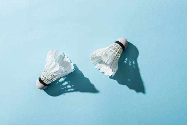 top view of white shuttlecocks with feathers on blue  - Foto, Imagem