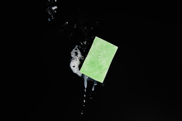 vista superior de esponja verde e colorida sobre fundo preto
  - Foto, Imagem